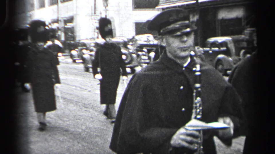 In 1937 Cleveland footage, a uniformed clarinet player stands close to camera as guards in tall hats march behind him.
