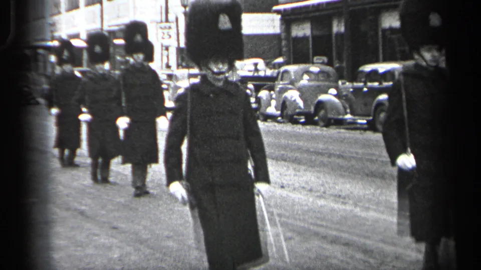A uniformed guard carrying a ceremonial staff marches toward the camera in the 1937 Cleveland street procession.