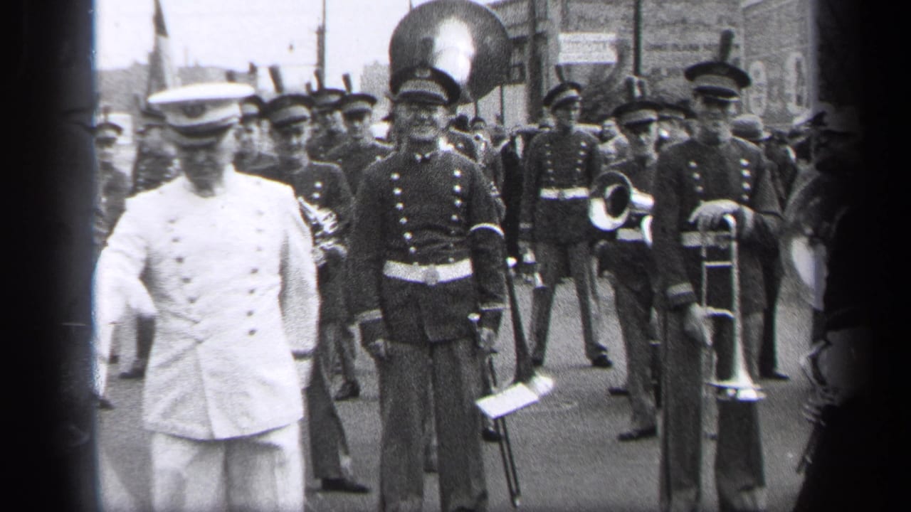 1937 Cleveland parade footage showing a white-uniformed baton leader in front of dark-uniformed marching band musicians.