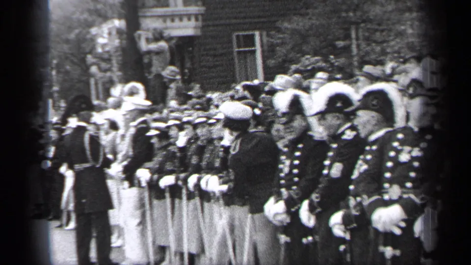 A Cleveland parade scene from 1937 shows uniformed participants facing the route with spectators gathered near brick buildings.
