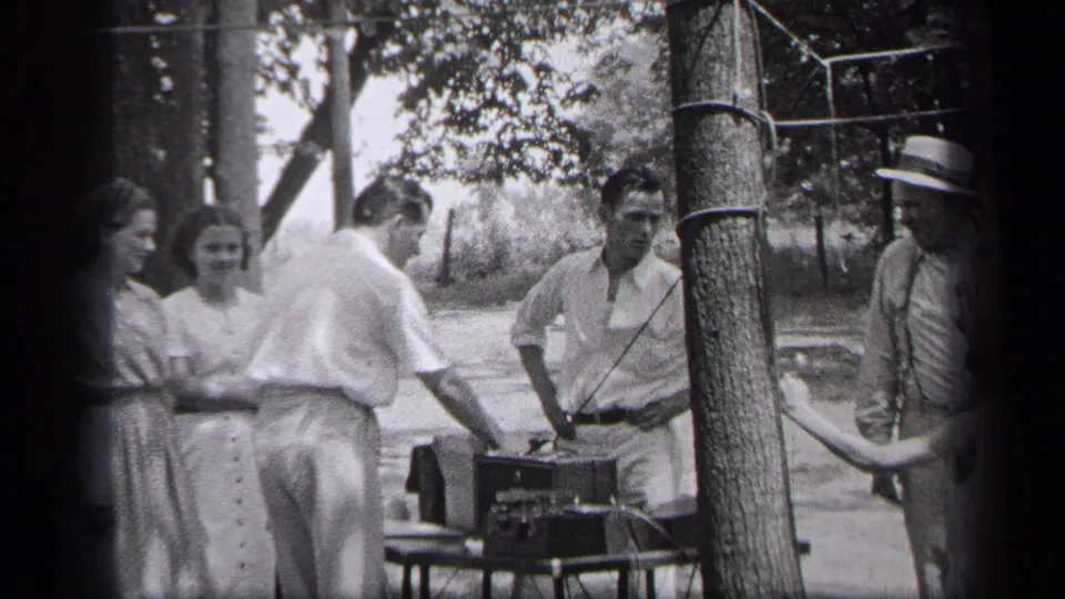 In this 1937 Cleveland home-movie frame, a man tends to the record player as friends look on outdoors.