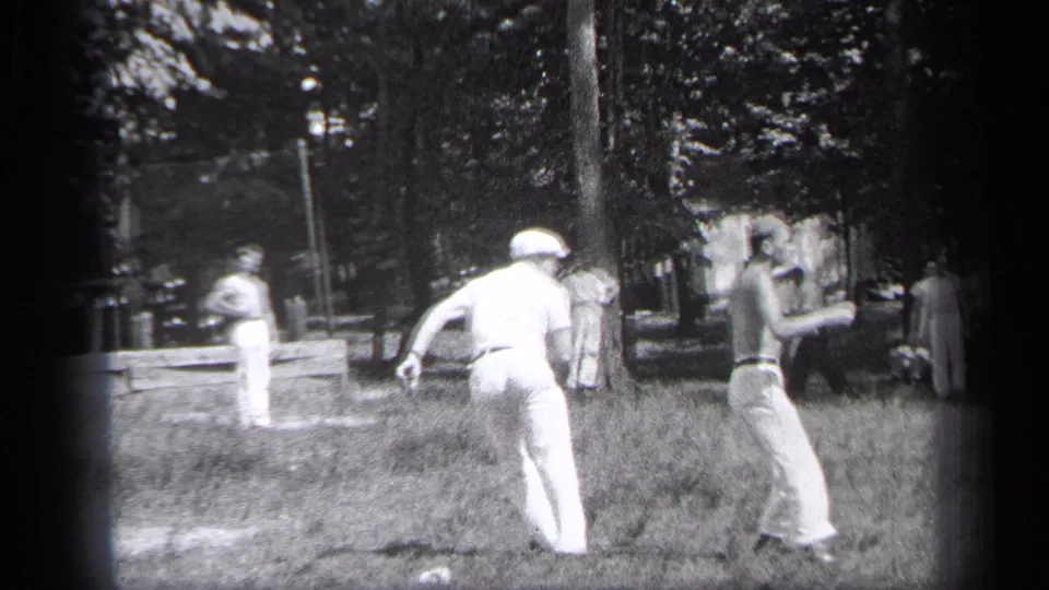 1937 Cleveland park baseball scene with a man running in white clothing while another player or spectator stands nearby.