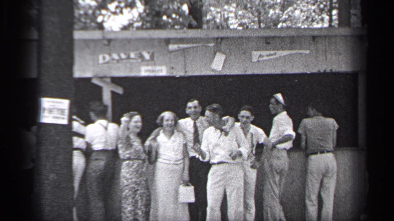 Adults stand and greet each other outside a shaded structure marked DAVEY.