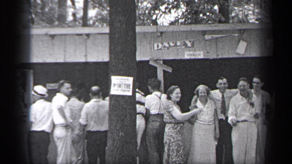 At the end of the clip, adults remain gathered outside the DAVEY-marked venue, with a woman gesturing during the reunion.