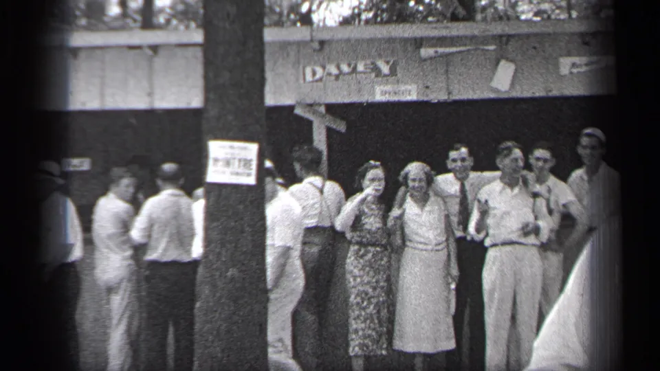 1937 Cleveland frame with adults posing or watching near the DAVEY sign as passersby cross the foreground.