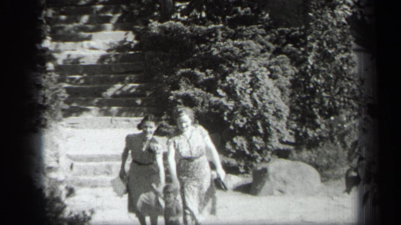 Two women walk down garden steps with a small child partly visible near them.