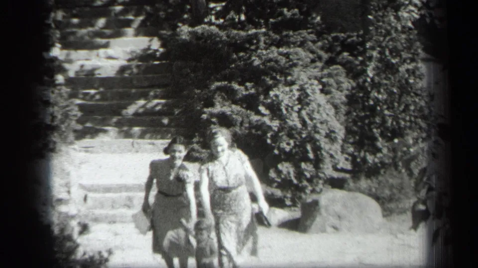 In 1938 Cleveland home-movie footage, two women descend outdoor stone steps with a small child partly visible at the lower left.