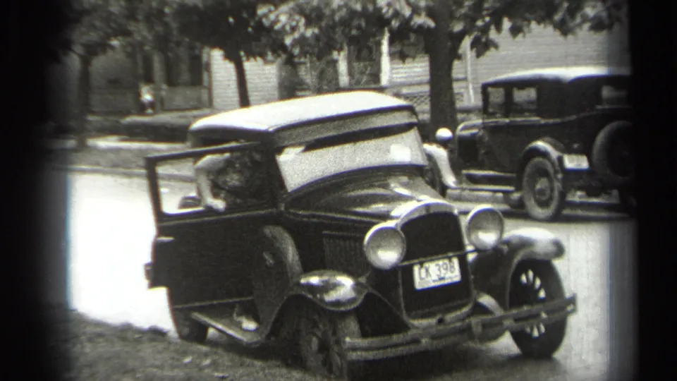 Final frame shows the adult at the open sedan door, the car's rounded front and plate visible on a quiet Cleveland residential street.
