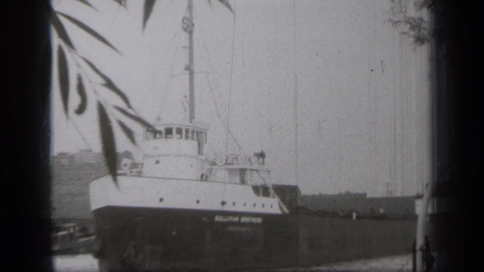 The Sullivan Brothers ship remains still in a Cleveland waterfront view, with its name visible along the dark hull.