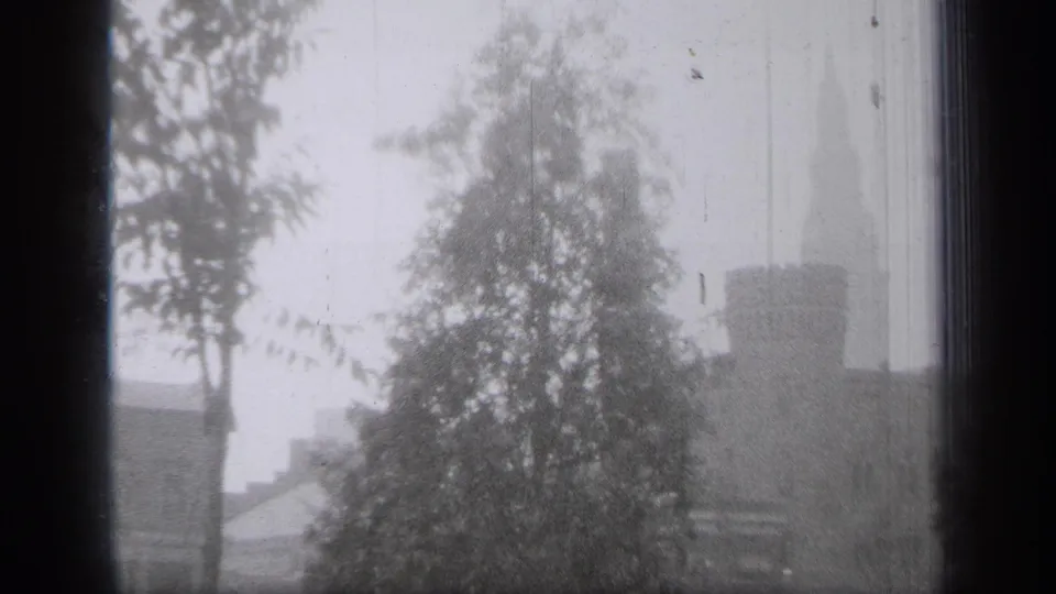 The final 1938 Cleveland frame holds on snowy trees and a distant stone building with tower details at the right edge.