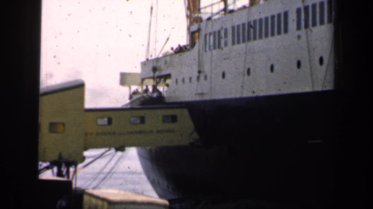 1949 England port scene with a large liner, visible portholes, and a yellow gangway where small figures gather below.