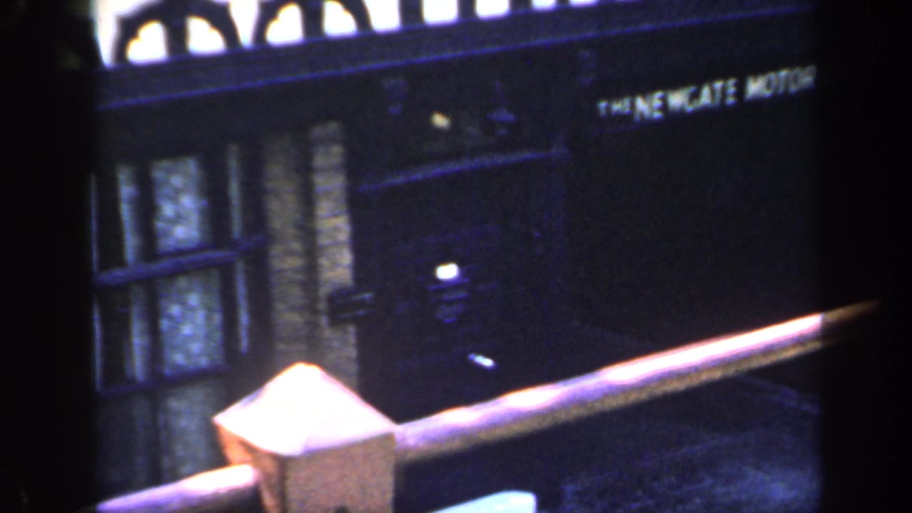 Dark-framed street frontage with a readable motor company sign and brick building details.