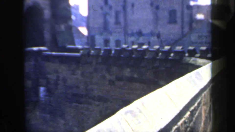 1949 England frame of a castle walkway and parapet, with a bright diagonal foreground wall and visible 8mm frame edge.