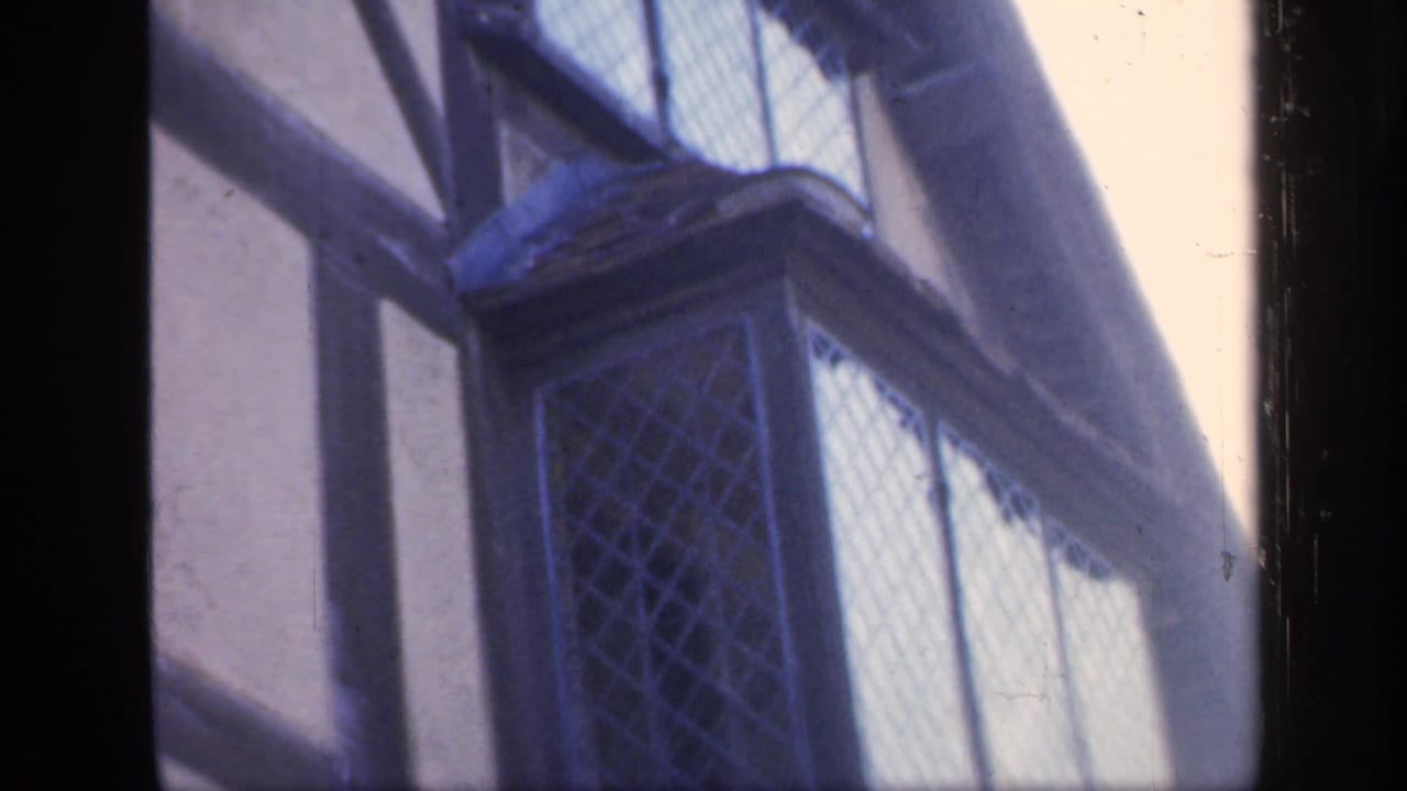1949 England frame with an angled view of upper leaded windows, timber beams and a projecting bay.