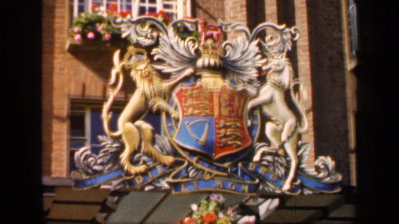 Heraldic coat of arms mounted on a brick building facade.