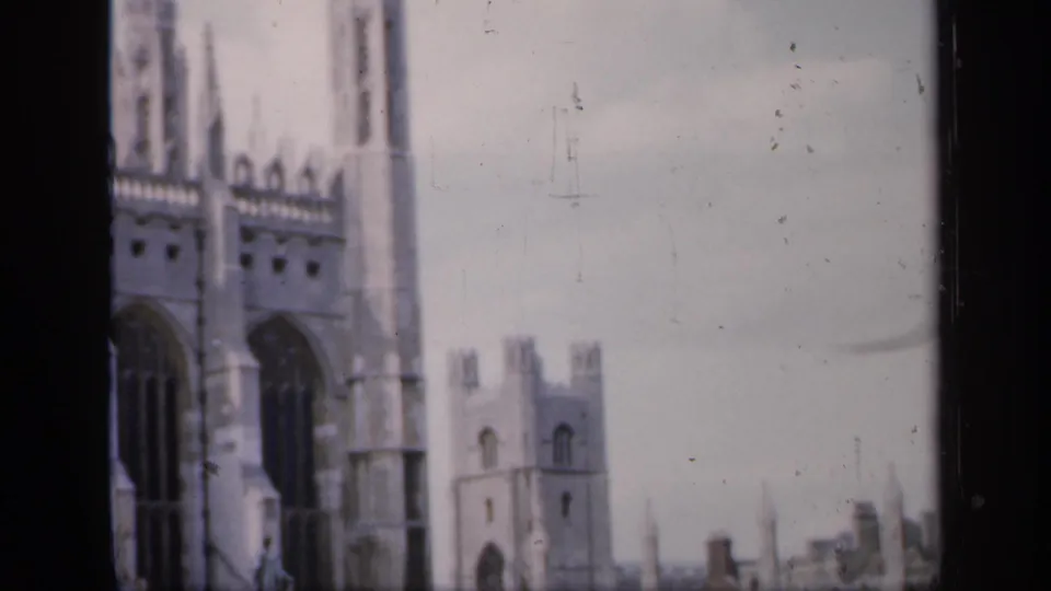 1949 England frame with tall Gothic windows, vertical spires, pale stonework, and a smaller tower visible beyond the cathedral facade.