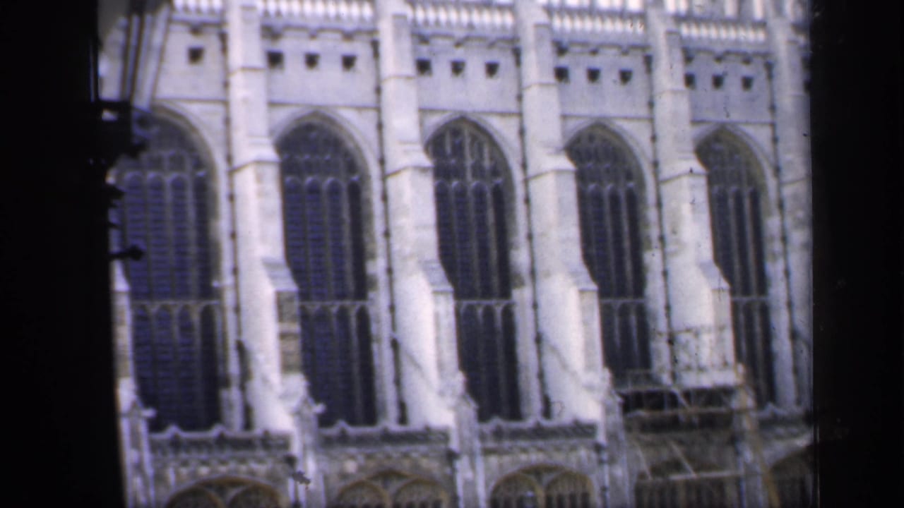 Gothic cathedral facade with tall arched windows and dark film borders.