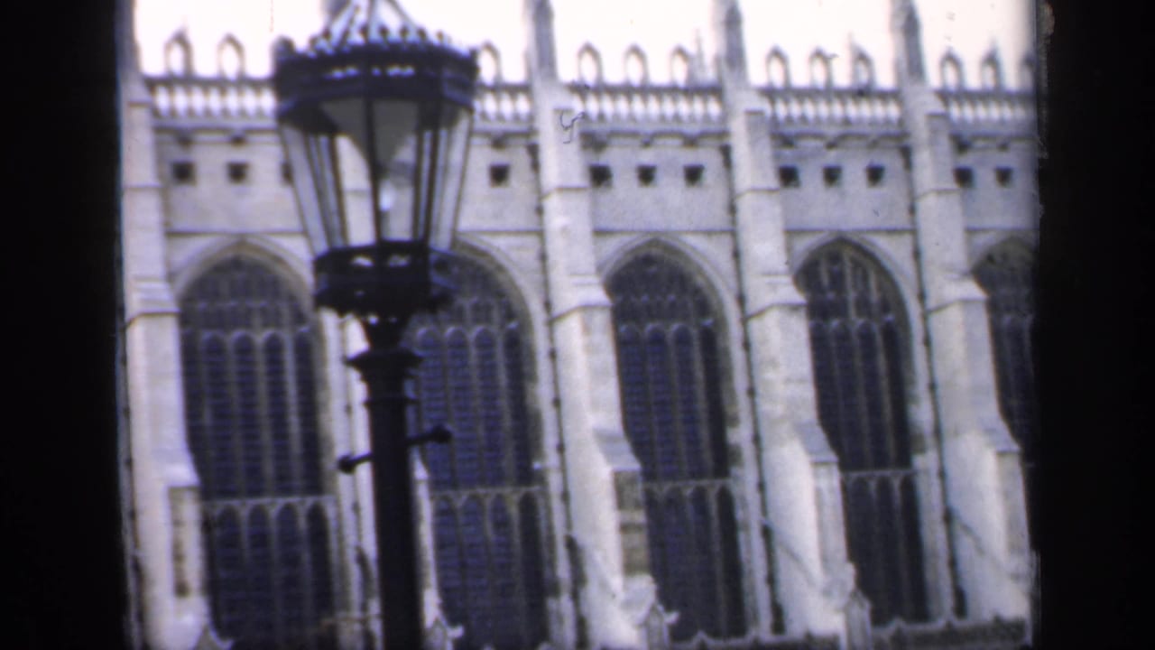 1949 England 8mm frame showing Gothic cathedral windows with a black lamppost crossing the foreground.