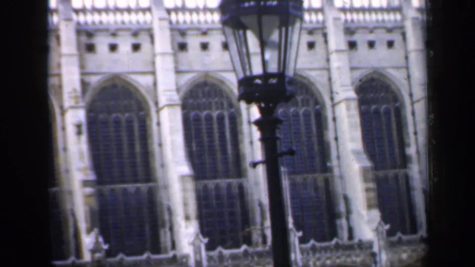 1949 England 8mm sightseeing frame with a lamppost centered before tall Gothic cathedral windows and pale masonry.