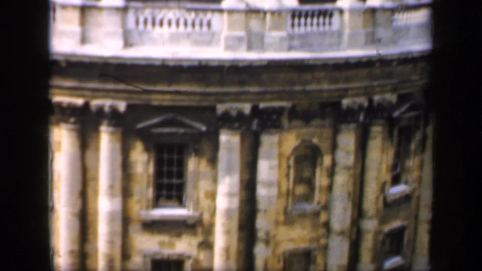 1949 Oxford 8mm frame showing a rounded stone building facade with columns, windows, balustrade and weathered architectural detail.