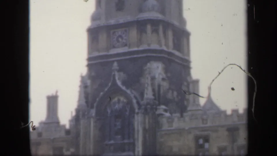1949 England frame showing the cathedral tower, upper stone facade, roofline, and visible film dust at the edge.