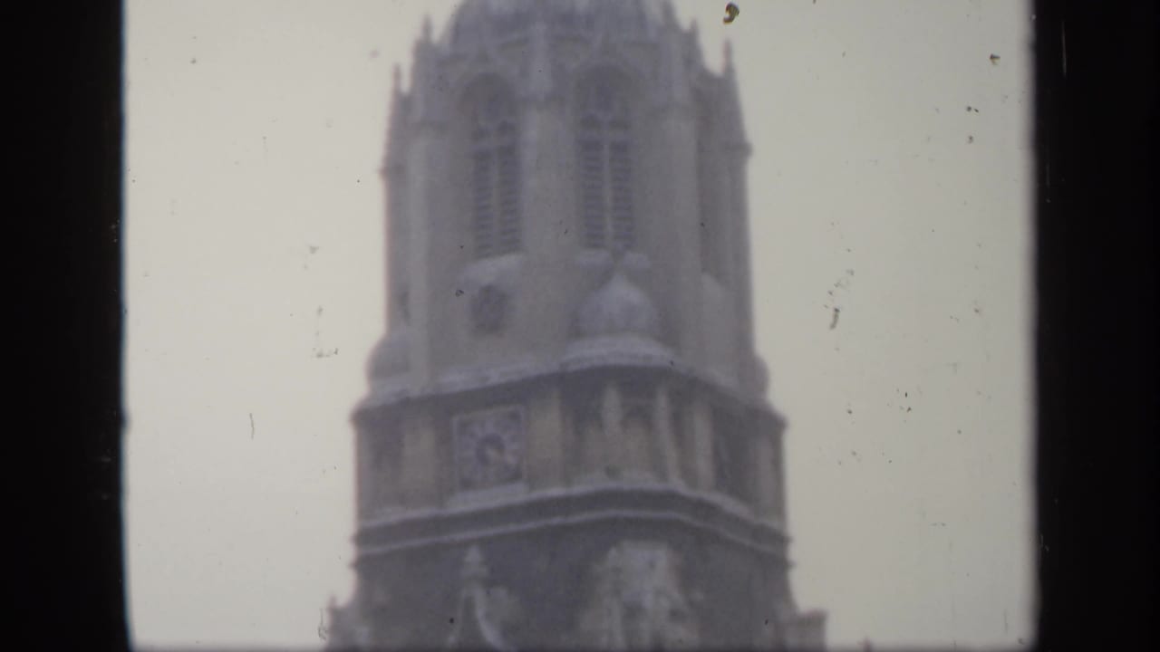 1949 England frame with the upper section of a historic stone tower, softened by exposure haze, grain, and visible film wear.