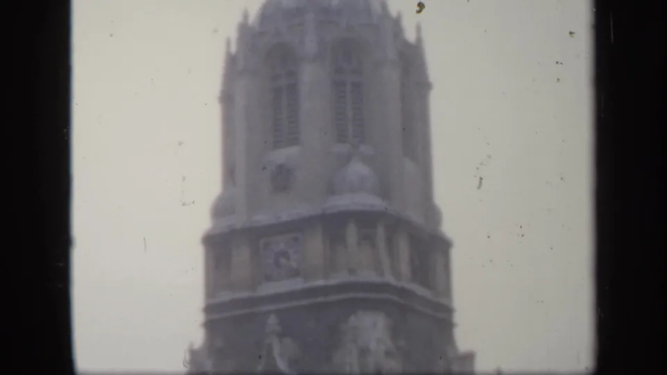 1949 England frame with the upper section of a historic stone tower, softened by exposure haze, grain, and visible film wear.