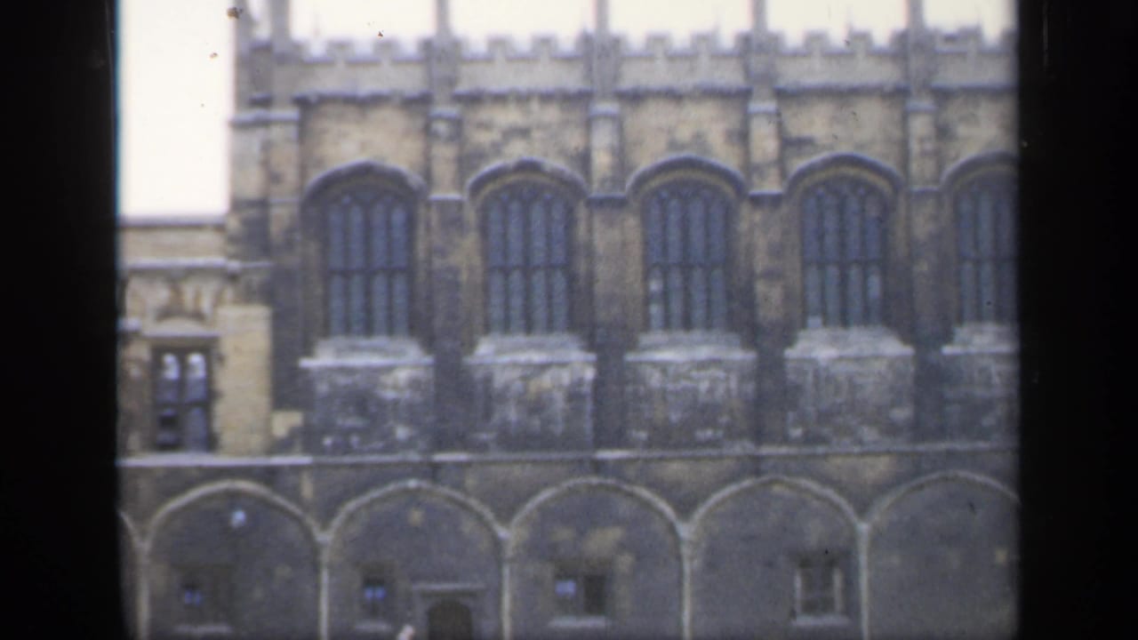 Stone building facade with repeated arched windows and lower arches.