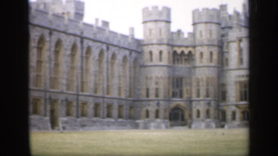 1949 England 8mm view of a castle-like stone exterior with round towers, arched windows, and an open lawn.