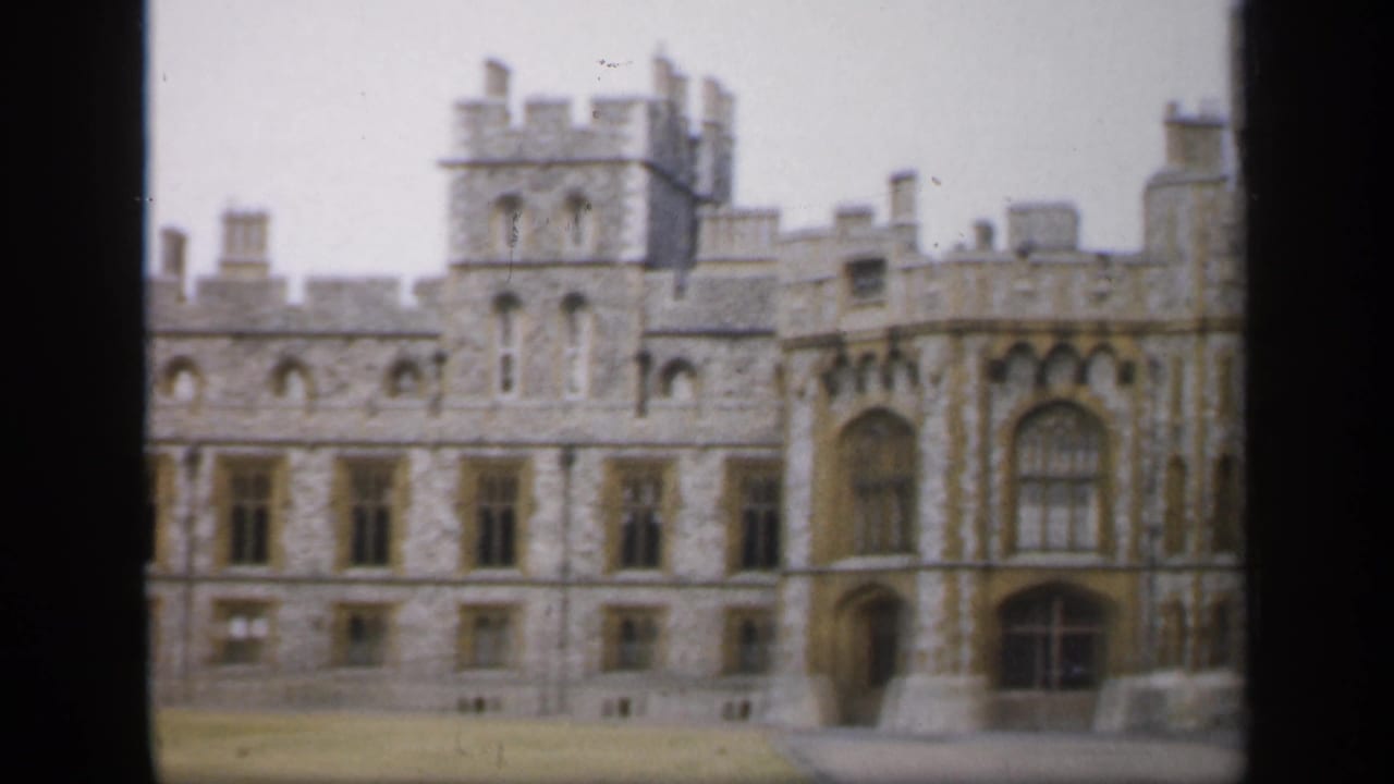 1949 England 8mm frame showing a broad stone castle elevation with crenellations, arched windows, and soft home-movie focus.