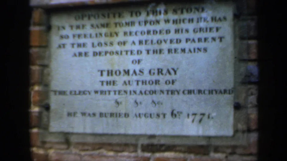 Close 8mm view of a memorial plaque in England naming Thomas Gray, author of Elegy Written in a Country Churchyard.