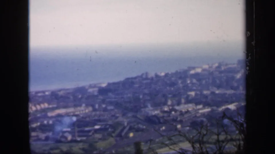 1949 England home-movie view of hillside buildings and a hazy seafront from a high overlook.