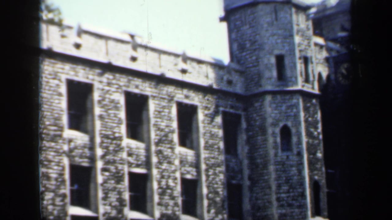 Stone building with tower seen from a shadowed viewpoint.