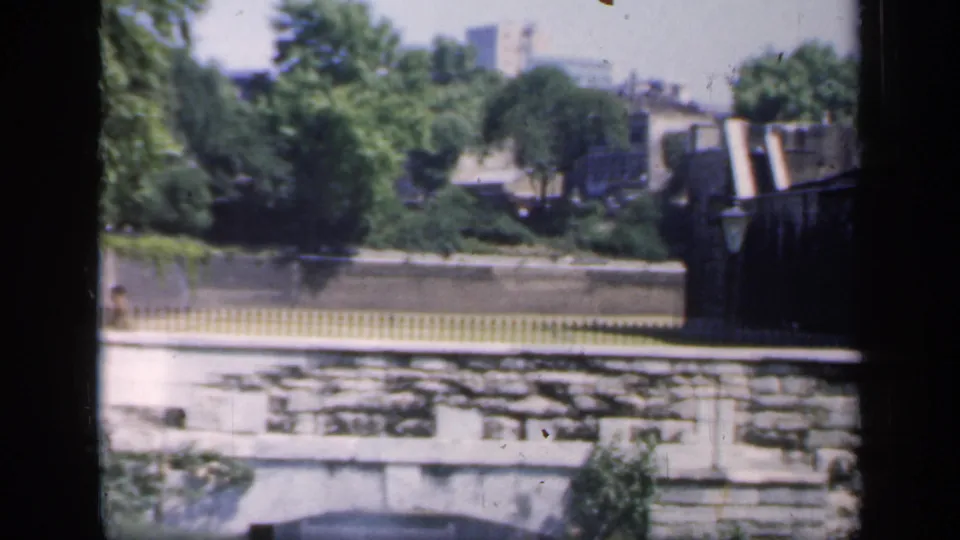 1949 England frame showing the park boundary, stone masonry, yellow fence, trees, and the edge of a fortified-looking structure.