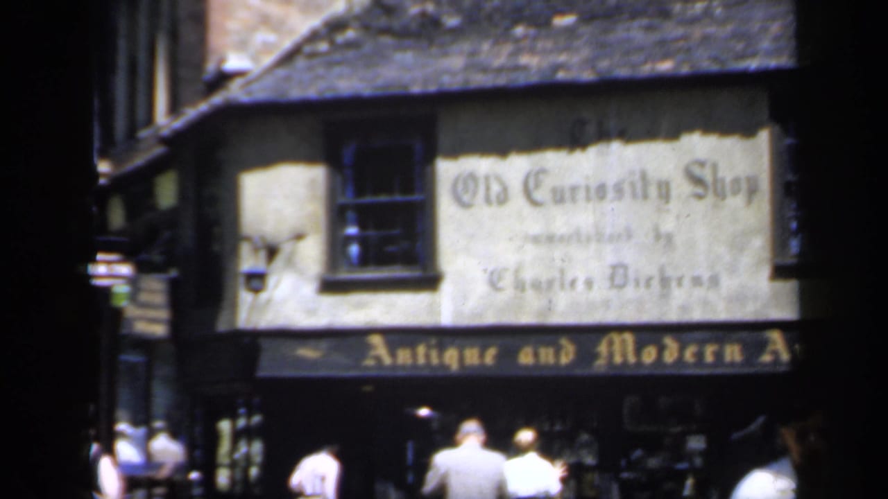 Old Curiosity Shop storefront with pedestrians passing on a narrow street.
