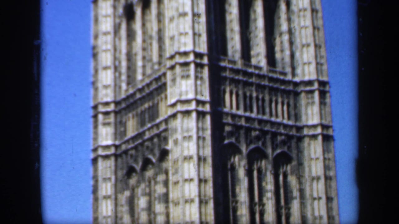 Close view of a Gothic stone tower section against blue sky.