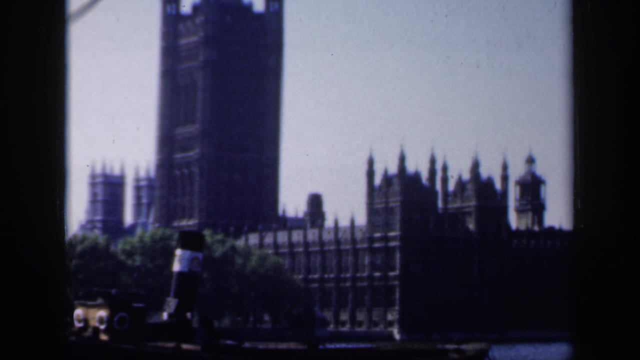 Late-1940s London landmark frame showing Westminster and Elizabeth Tower beyond trees and a small boat.