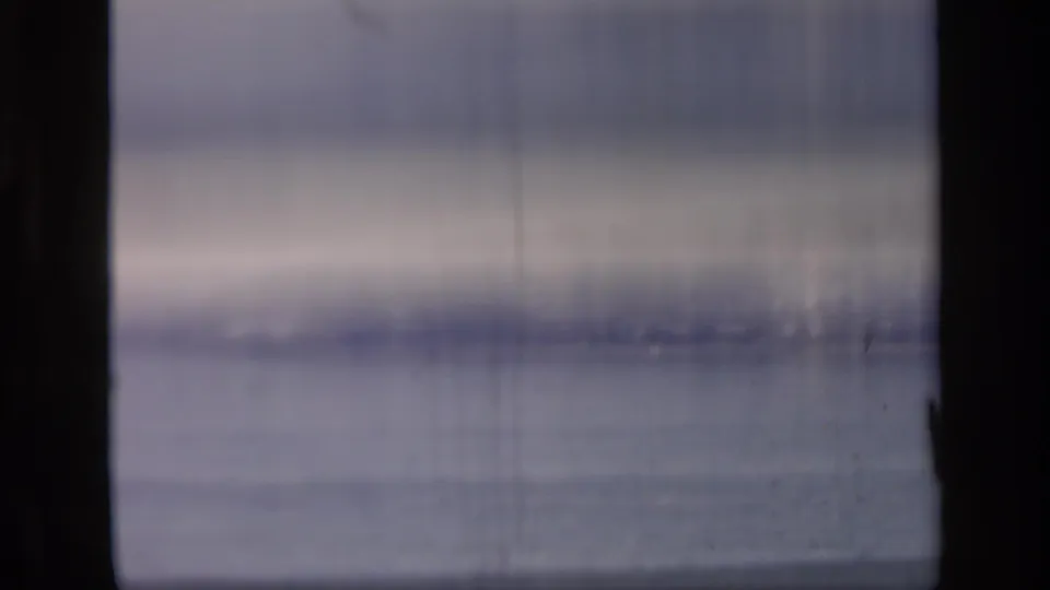 Soft 8mm frame dominated by the Thames surface, with muted color, vertical film marks, and little distinct detail.
