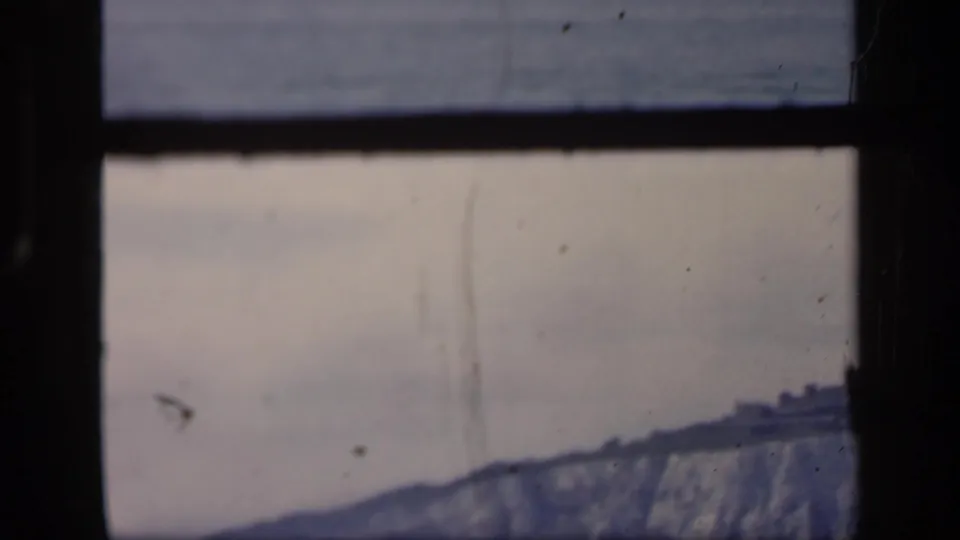 1949 London Thames view with a hazy riverside skyline, pale sky, dark frame edges, and visible 8mm film wear.