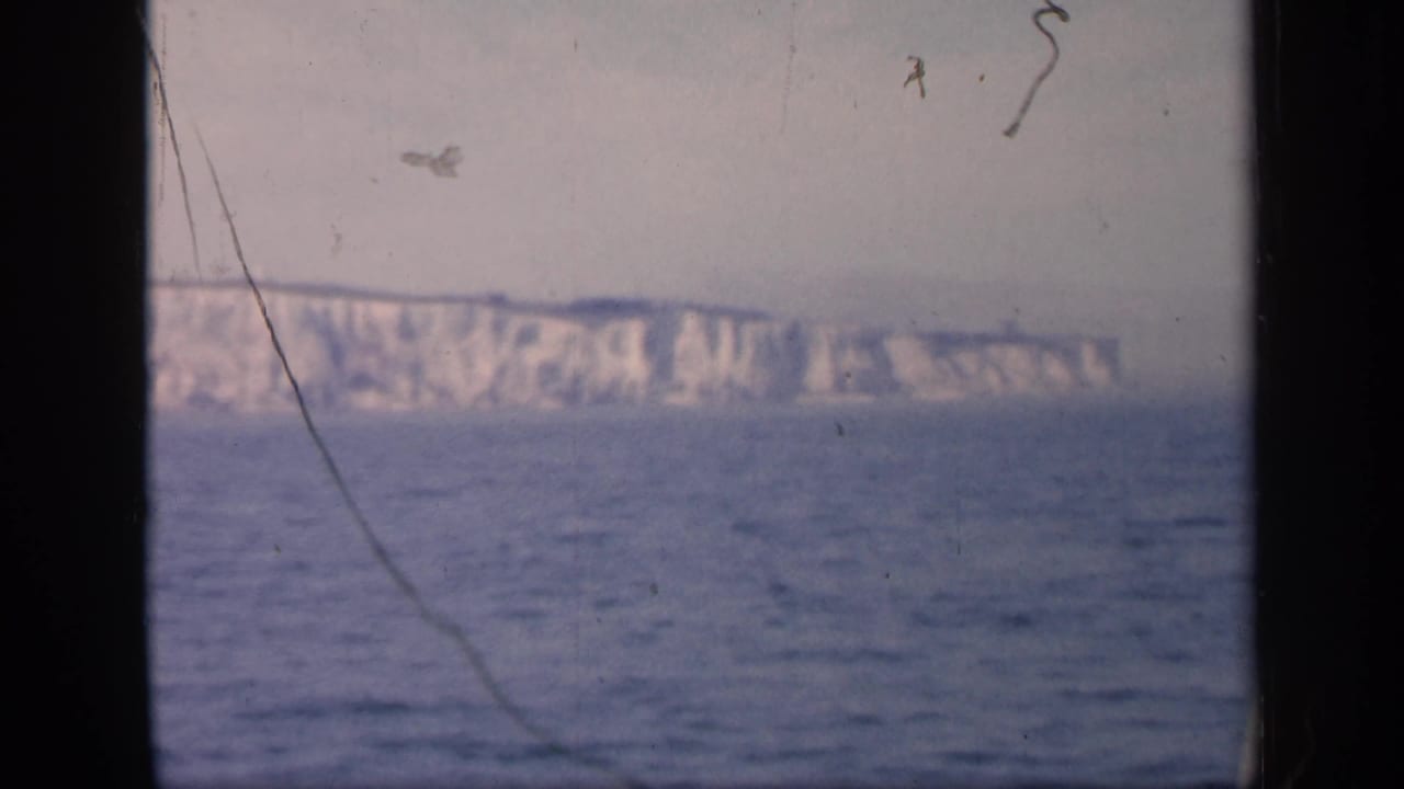 Final frame of the 1949 England clip shows the Dover cliffs across the water, with a dark central window bar and visible film scratches.