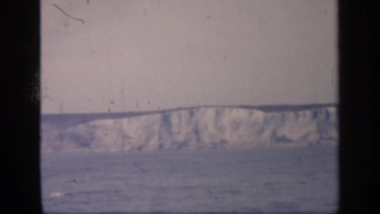 Pale cliffs or hillside above water with dark 8mm frame edges.