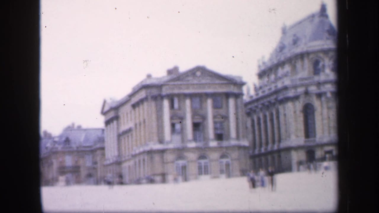Wide French square with columned buildings, a rounded roofline, and small pedestrians.