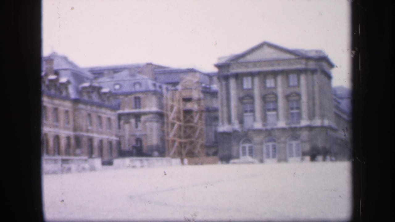 Historic building complex in snow with scaffolding beside a columned facade.