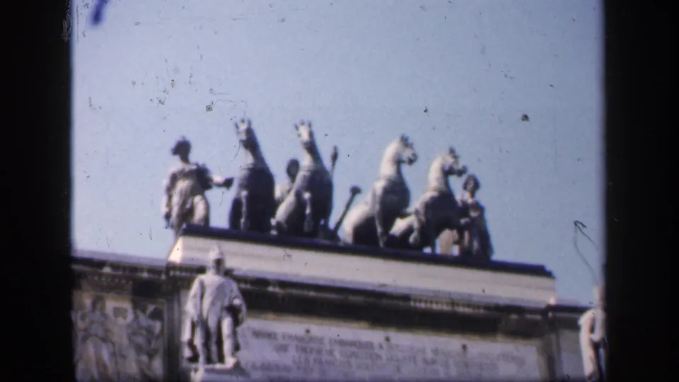 1949 Paris home-movie frame showing a rooftop quadriga sculpture and stone monument detail against a clear sky.