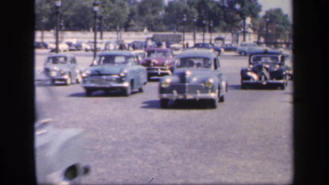 1949 France traffic scene with multiple mid-century cars moving toward the camera on a broad urban road.