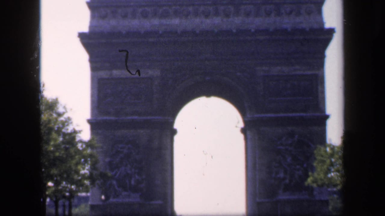 Closer view of the Arc de Triomphe with trees and a dark central bar.