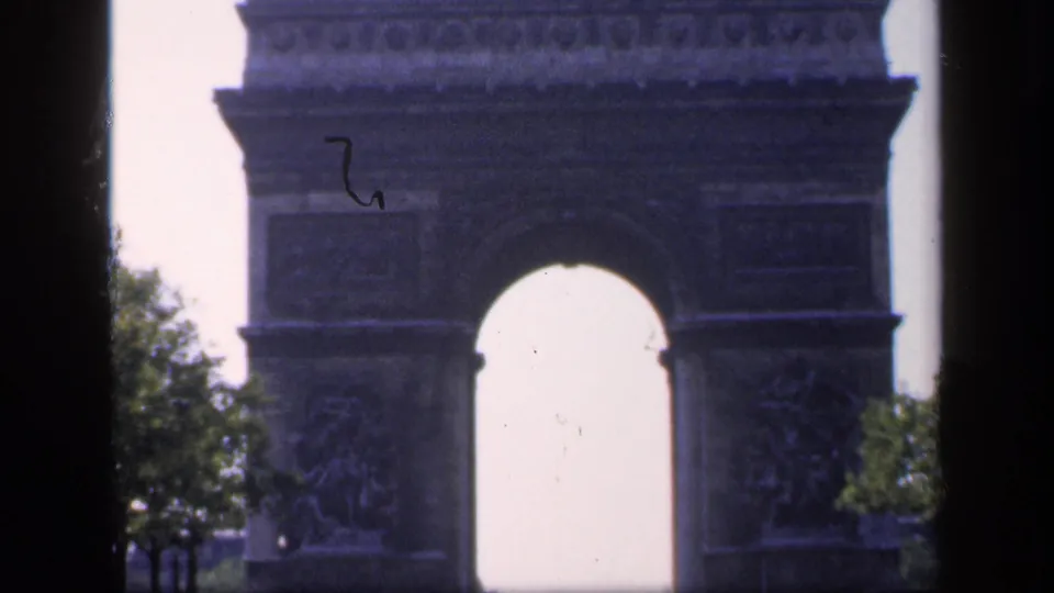 The Arc de Triomphe fills the frame in a 1949 Paris view, partly obscured by a dark vertical window or vehicle frame.