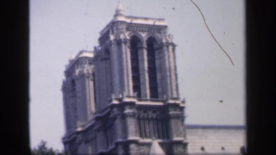 1949 8mm view of Notre-Dame Cathedral stone tower in Paris, framed close with soft focus and visible film wear.