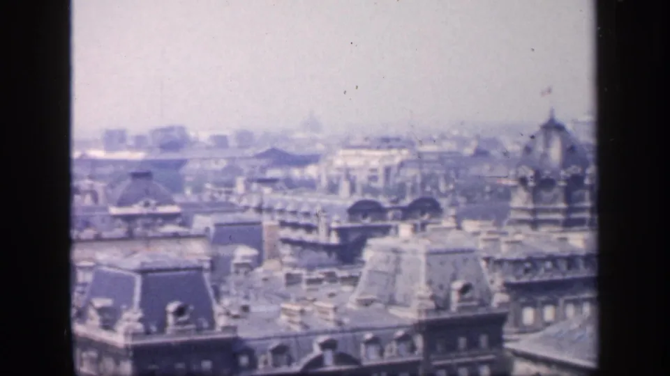 1949 France frame showing a hazy urban panorama with mansard roofs, distant blocks, and a rounded roof feature near the right side.
