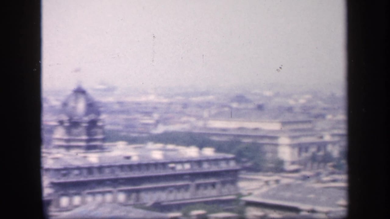 Hazy elevated view across New York City buildings with a domed roof at left.